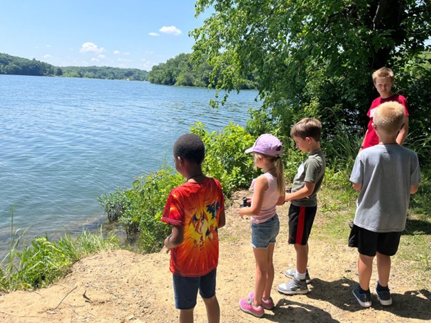 group of children standing on the edge of Wyandotte County Lake near Mr. & Mrs. F. L. Schlagle Library