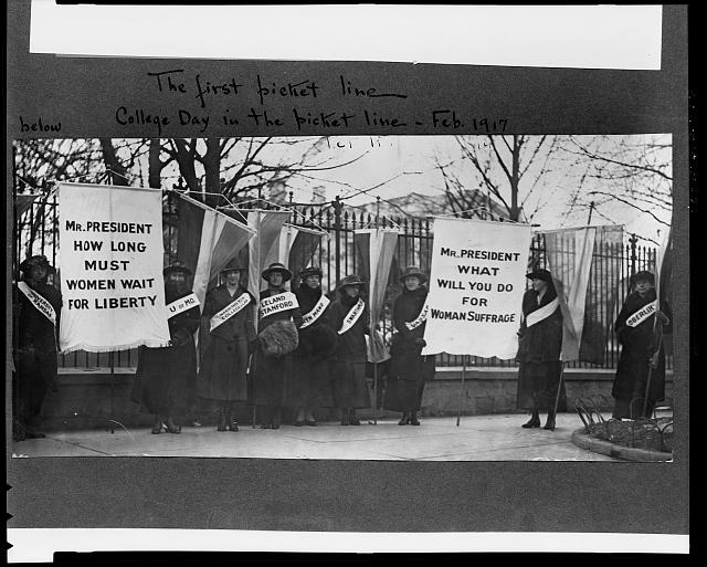 historic black and white image of woman holding signs in front of the White House in the 1913 Suffrage Pageant