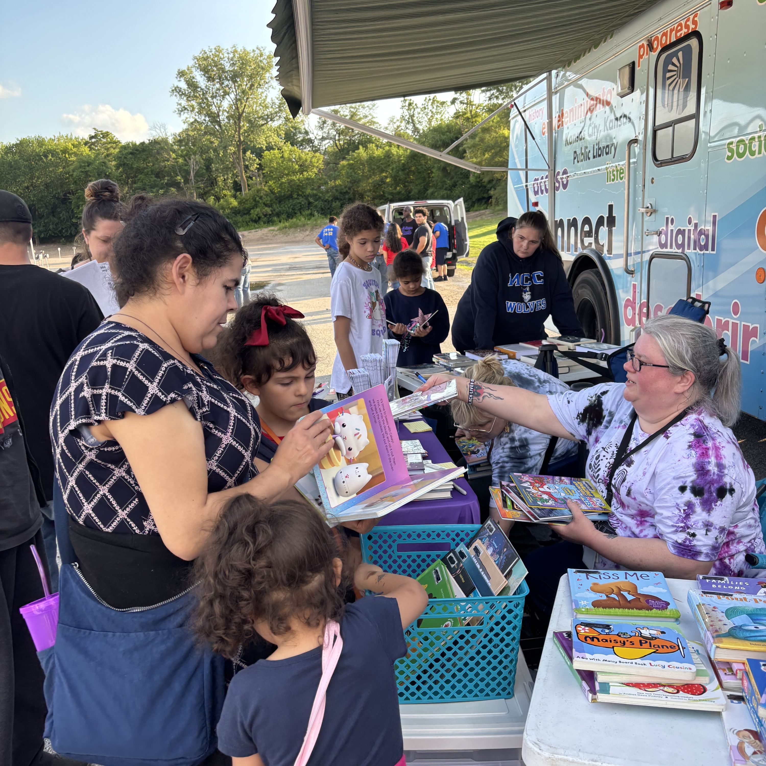 mobile library associates handing out books to people at the 2025 summer reading kickoff party