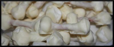 A pile of small candies covered in white chocolate that look like little bones, with a black border around the image