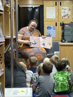 Lina, the mobile services manager, reads storytime to children on a KCKPL mobile library bus