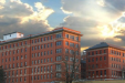 red brick hospital building with bright cloud sky behind