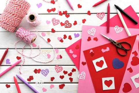 Pink and red paper with scissors and heart shapes