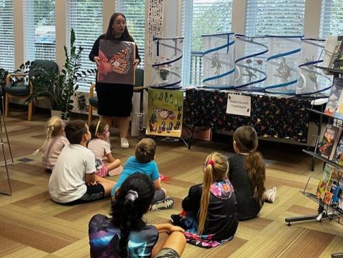 Instructor sharing with participants about Monarch butterfly migration inside the library.