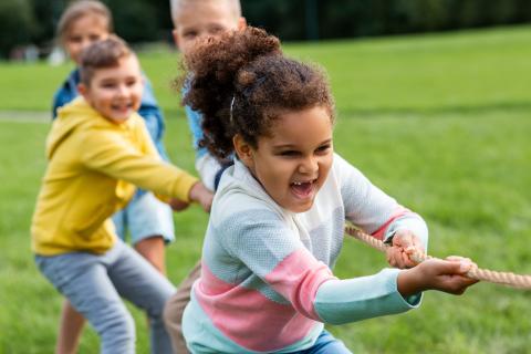 Children playing tug a war outside