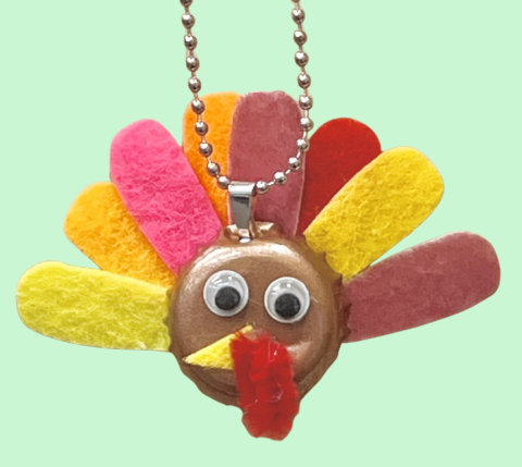 turkey face with felt feather on a bottle cap with a chain necklace