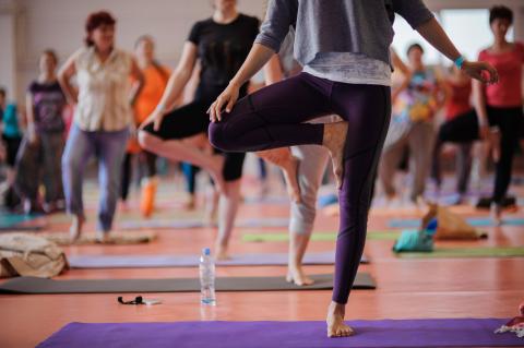 Women practicing yoga at health club