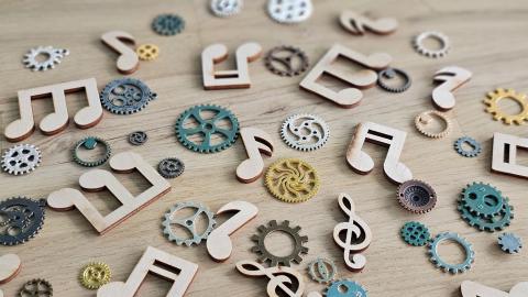 Colorful music notes and gears scattered on a wooden surface in a creative arrangement 