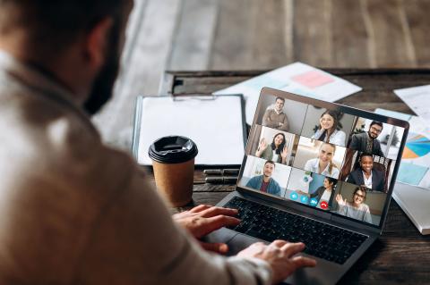 person looking at a computer screen with multiple people on a video call