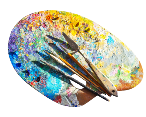 Painting palette full of the entire rainbow in paints. Dots of paint aligned around the edge of the palette. Brushes and palette knives resting on the paint palette.