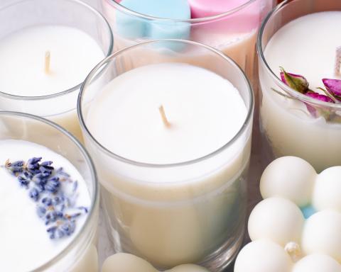 A photo is show of different white candles that have different scents like lavender and rose. 