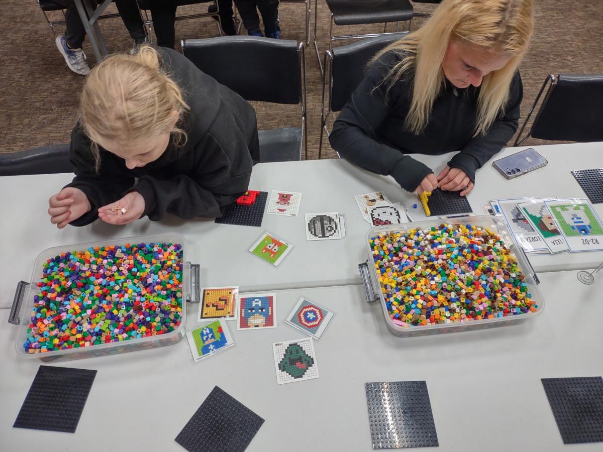 Two children building with Legos at a table.
