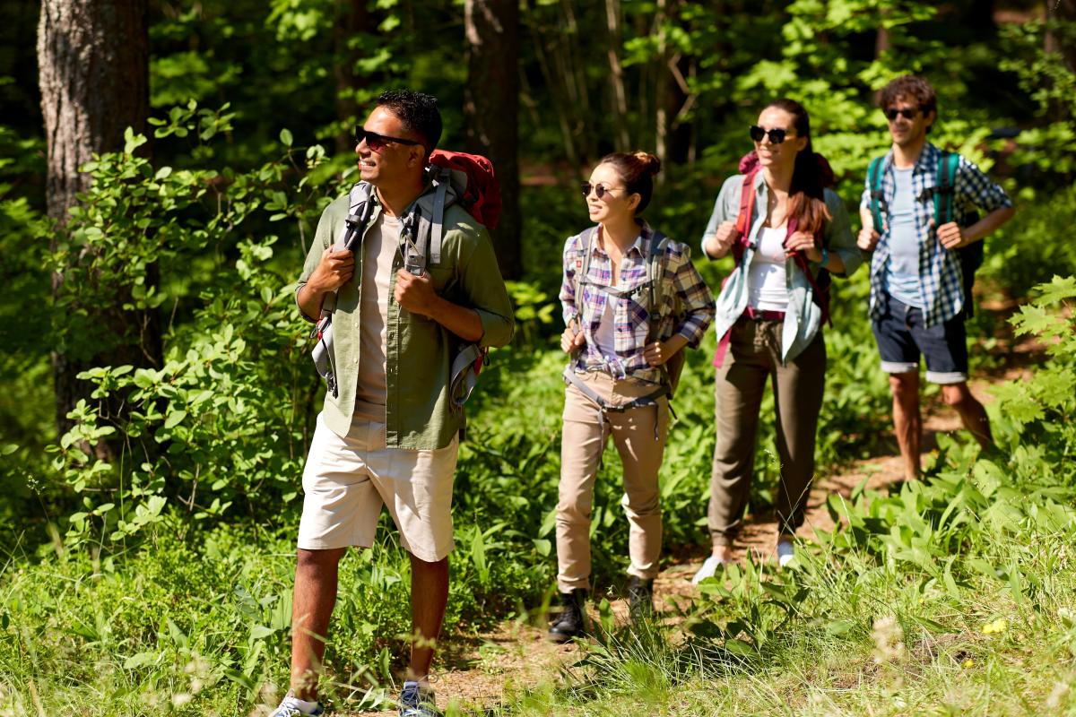 People hiking outdoors in a single file line
