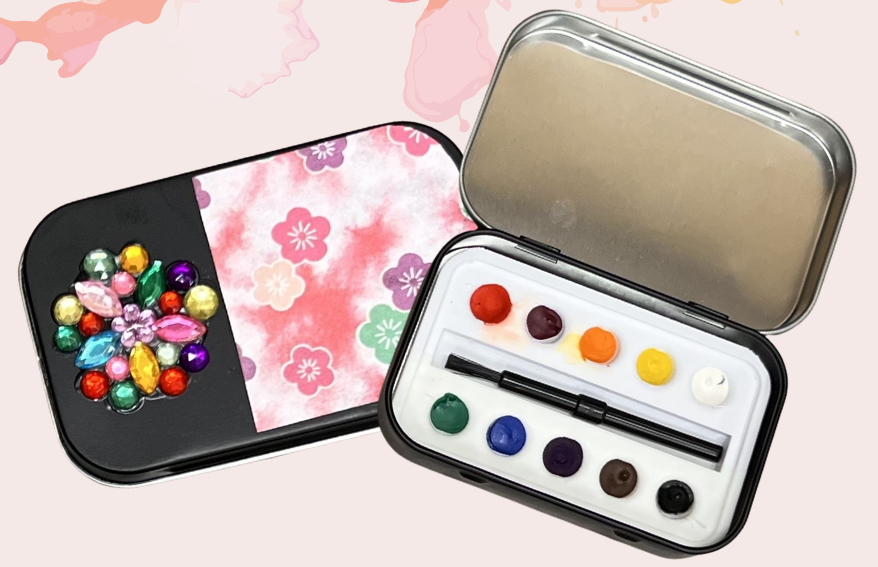 watercolor palette in small tin with paint brush