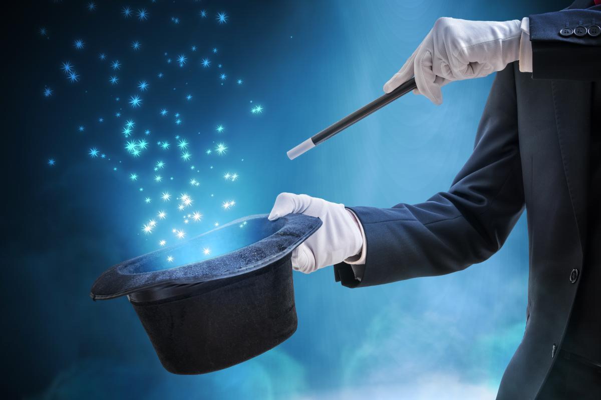magician waving magic wand over a top hat