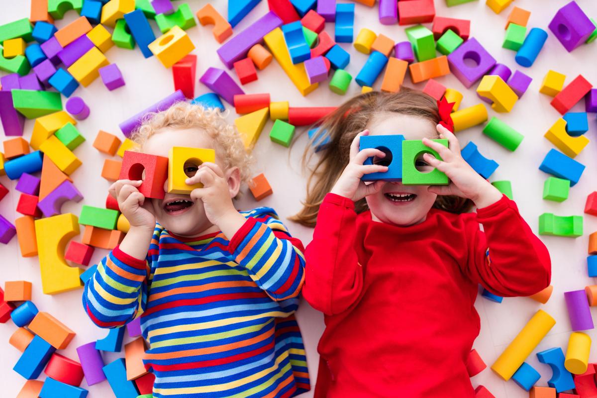 Children smiling, laying down with foam blocks around them