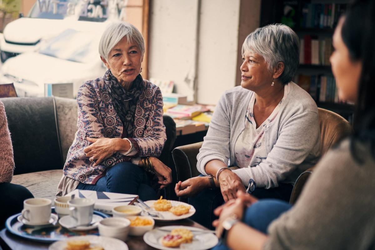 older women sitting in a cafe talking near a window