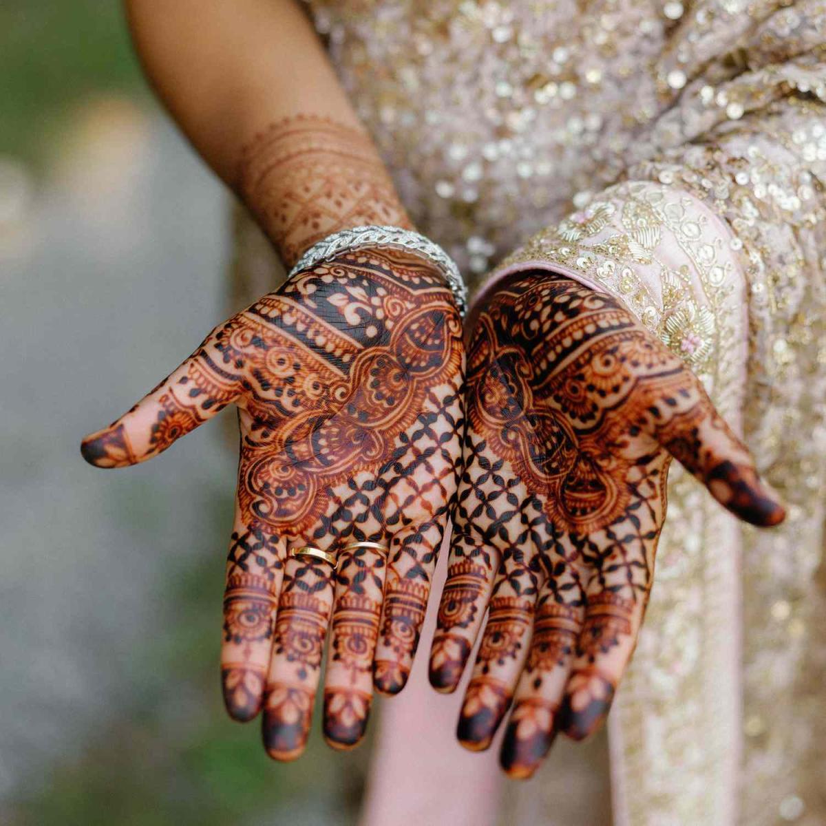 A set of hands with a detailed henna pattern
