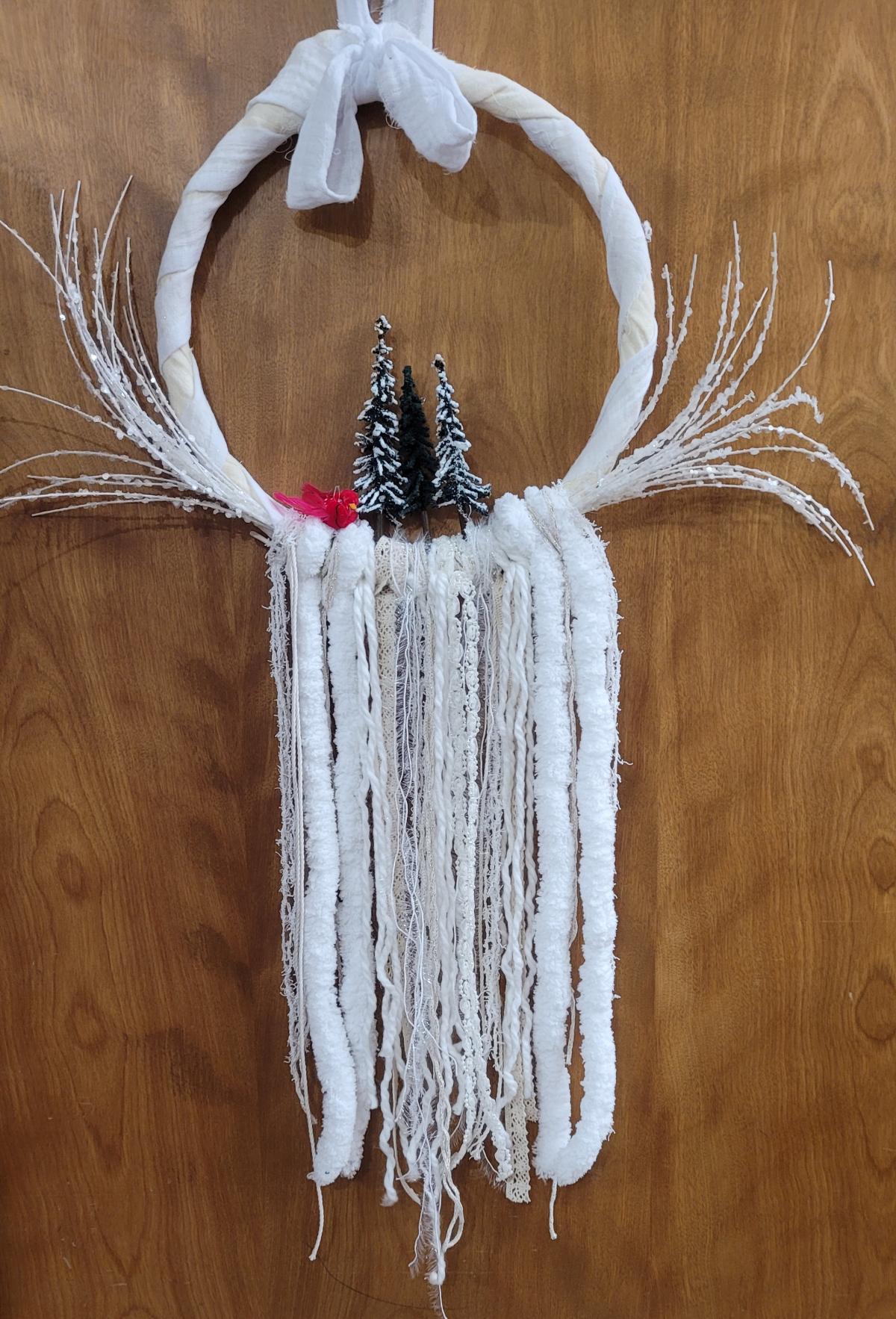 White wreath with red & green accents on a wood background