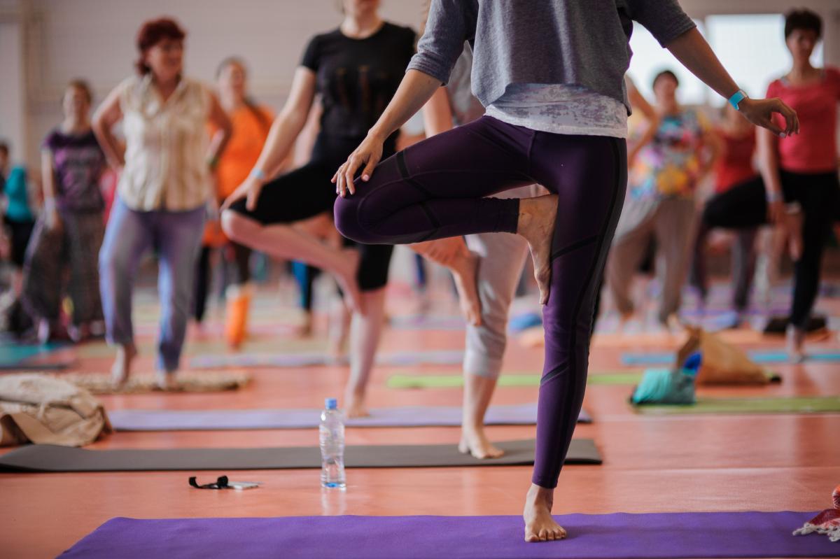 Women practicing yoga at health club