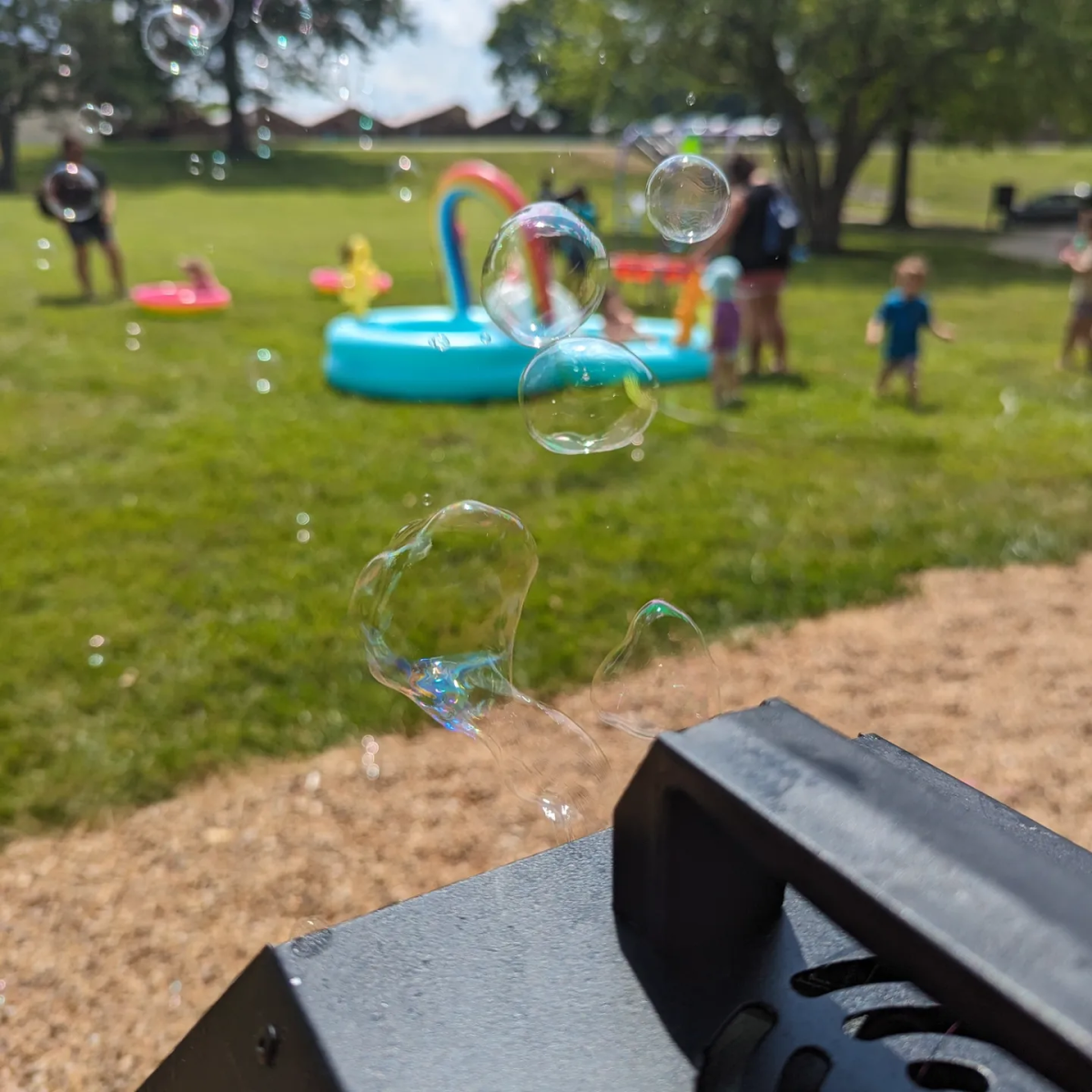 Splash Bash photo from 2024 showing bubbles and kids and parents playing in the background