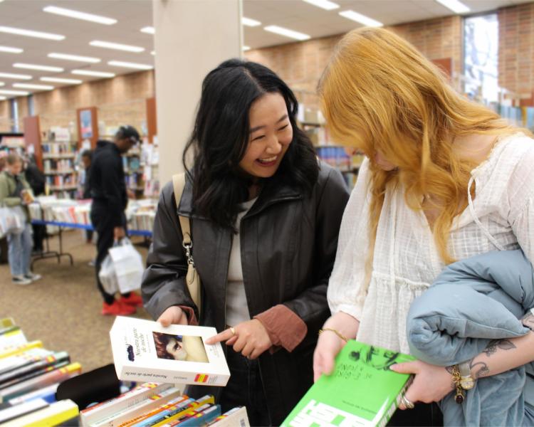 2 female friends laughing at the Main Library book sale